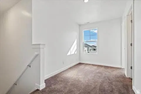 Carpeted room featuring a single window, white baseboards, and a recessed ceiling light