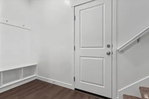 Entryway featuring wood-finish flooring and a white paneled door with brushed nickel hardware