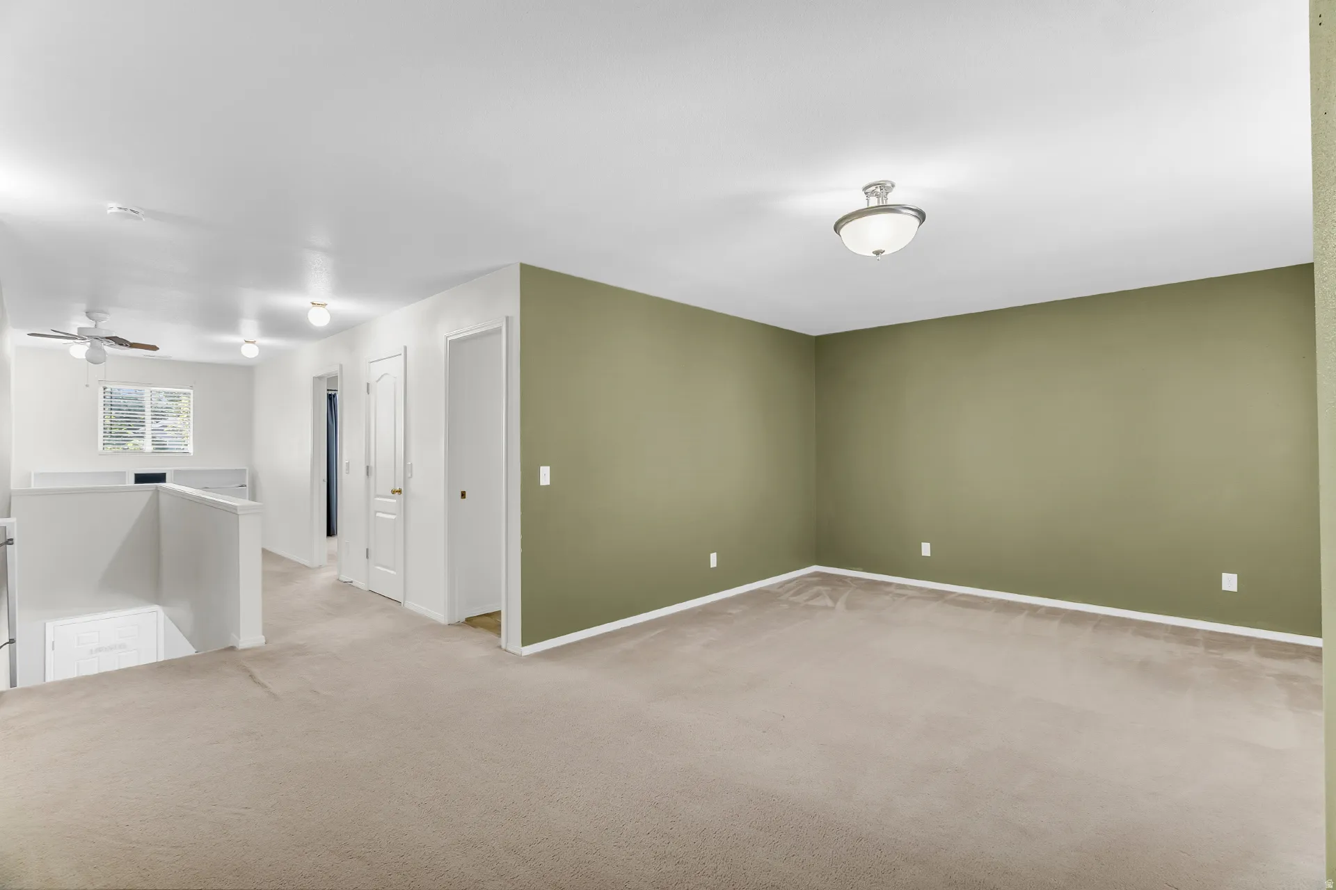 Carpeted upper-level space featuring a contemporary ceiling fan, flush-mount lighting, and a window with natural light