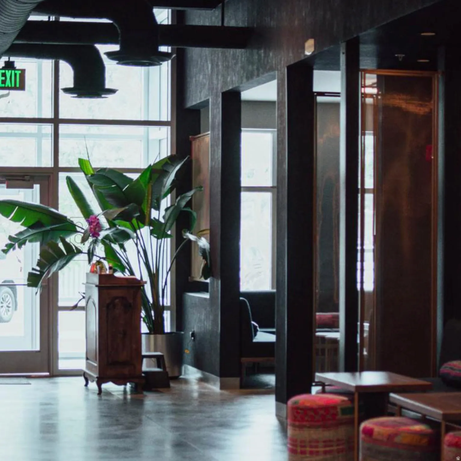 Lobby area featuring industrial-style exposed ductwork and a dark, textured wall finish