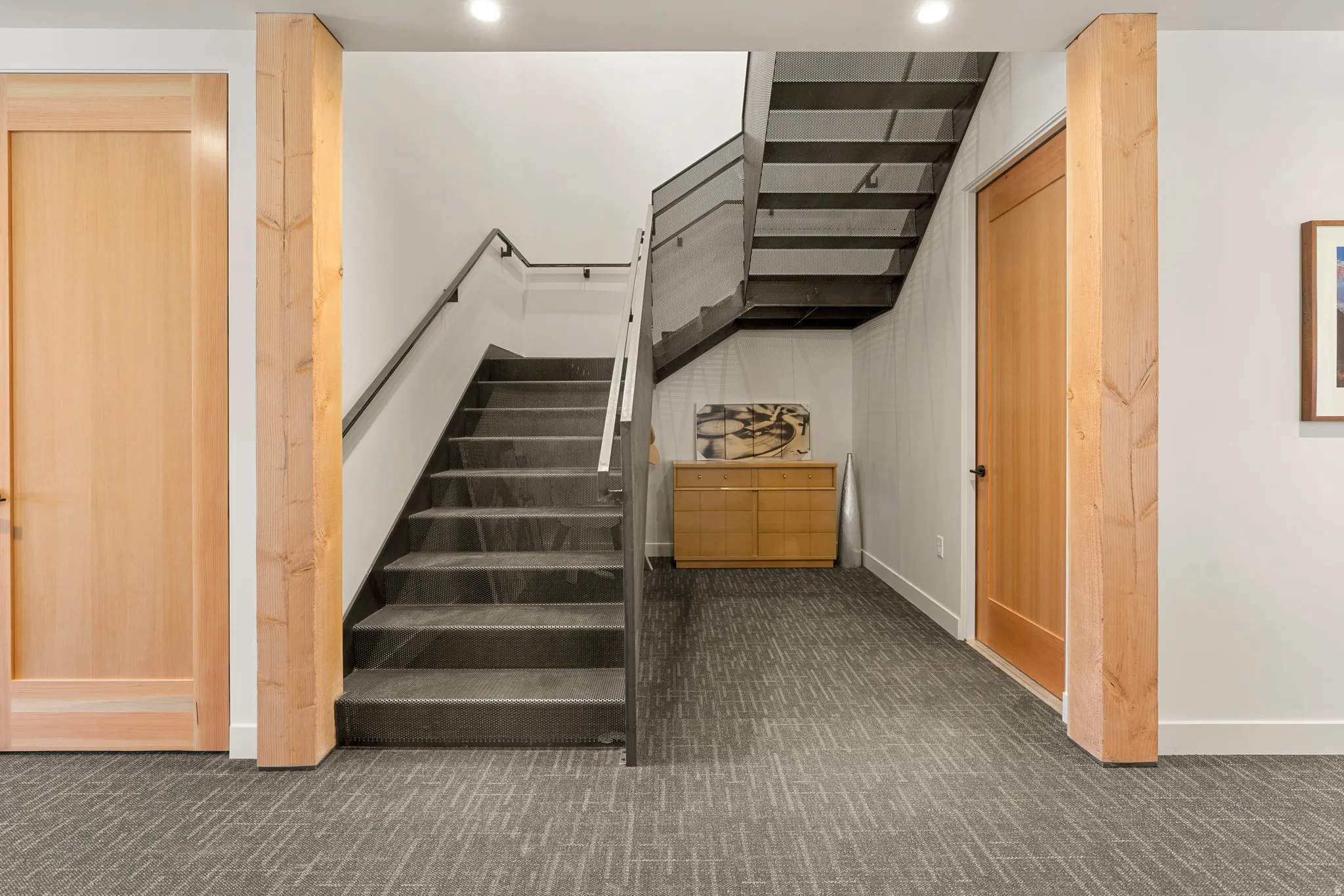 Modern staircase featuring dark stone treads and a black metal railing