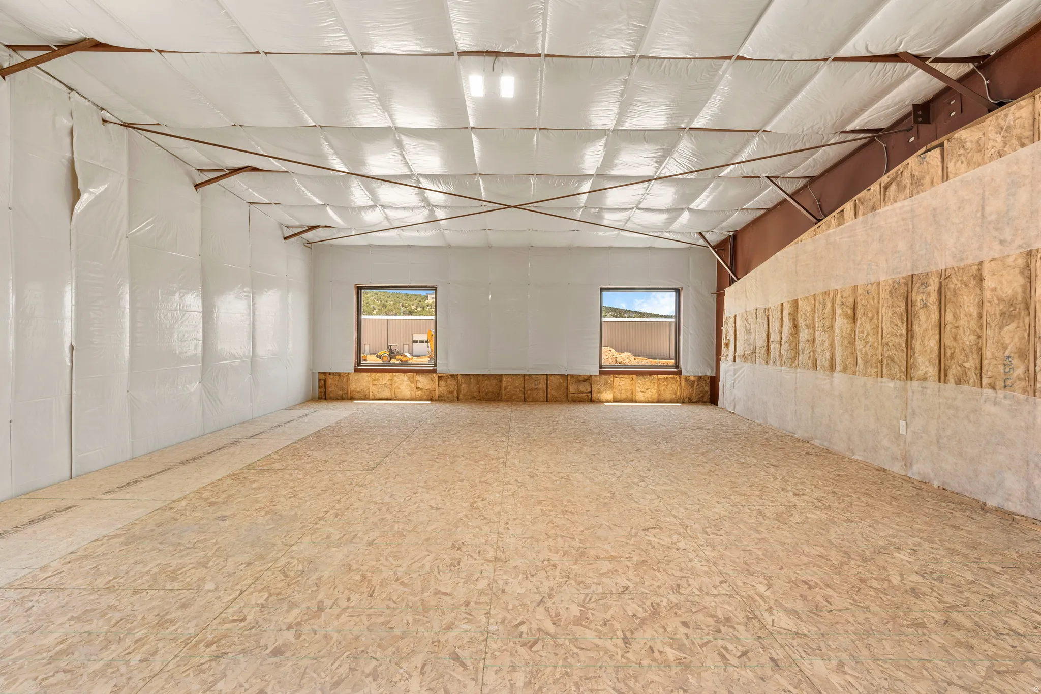 Expansive interior space featuring structural steel beams and a high ceiling