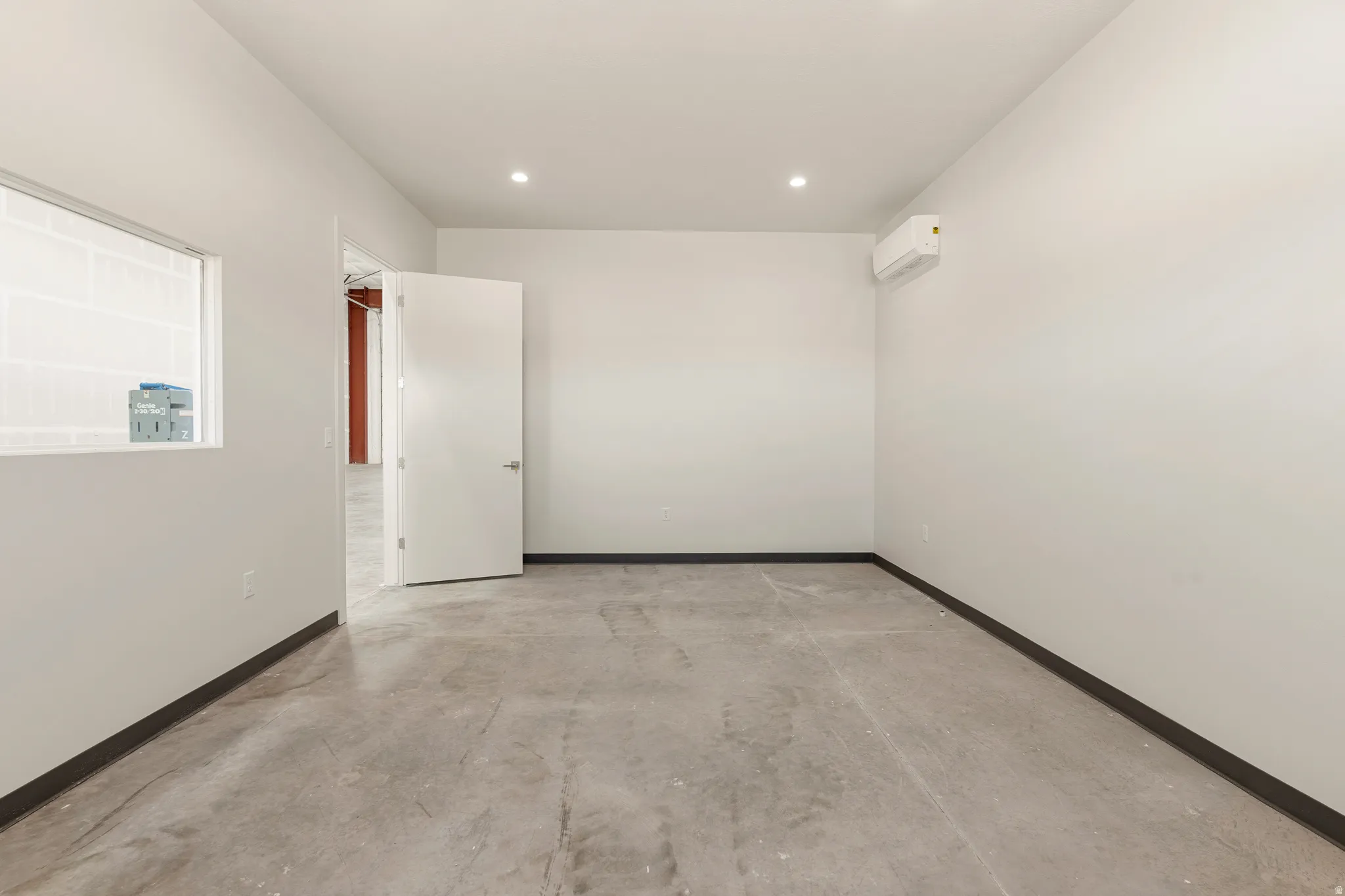 Interior room featuring concrete flooring and white painted walls