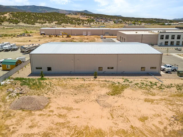 Expansive commercial building featuring a metal roof and light-colored siding
