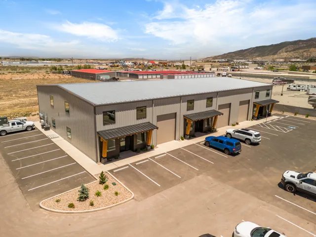 Multi-unit commercial building featuring corrugated metal siding, a metal roof, and multiple roll-up doors