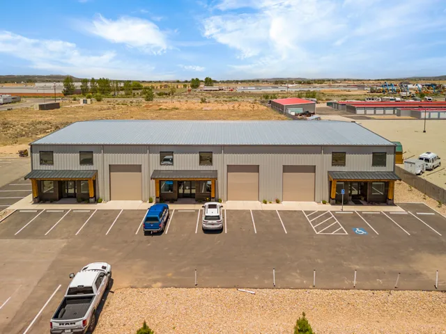 Commercial building with multiple units, each featuring a roll-up door and a separate entry with an overhang