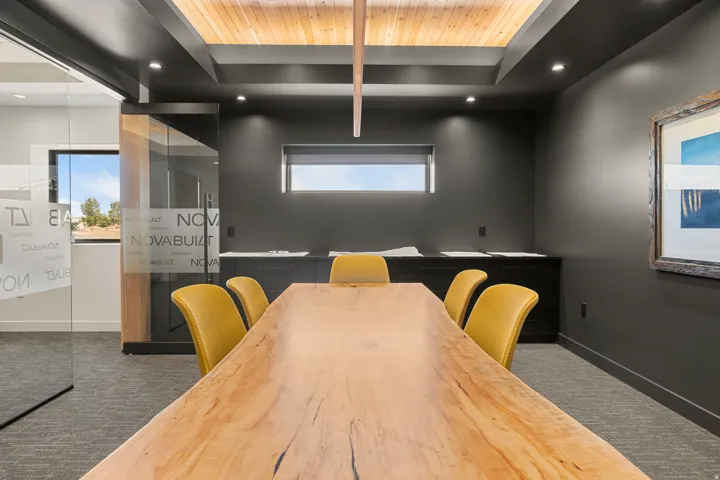 Conference room featuring a wood slab table, recessed lighting, wood-finish ceiling paneling, and an accent wall with a framed artwork