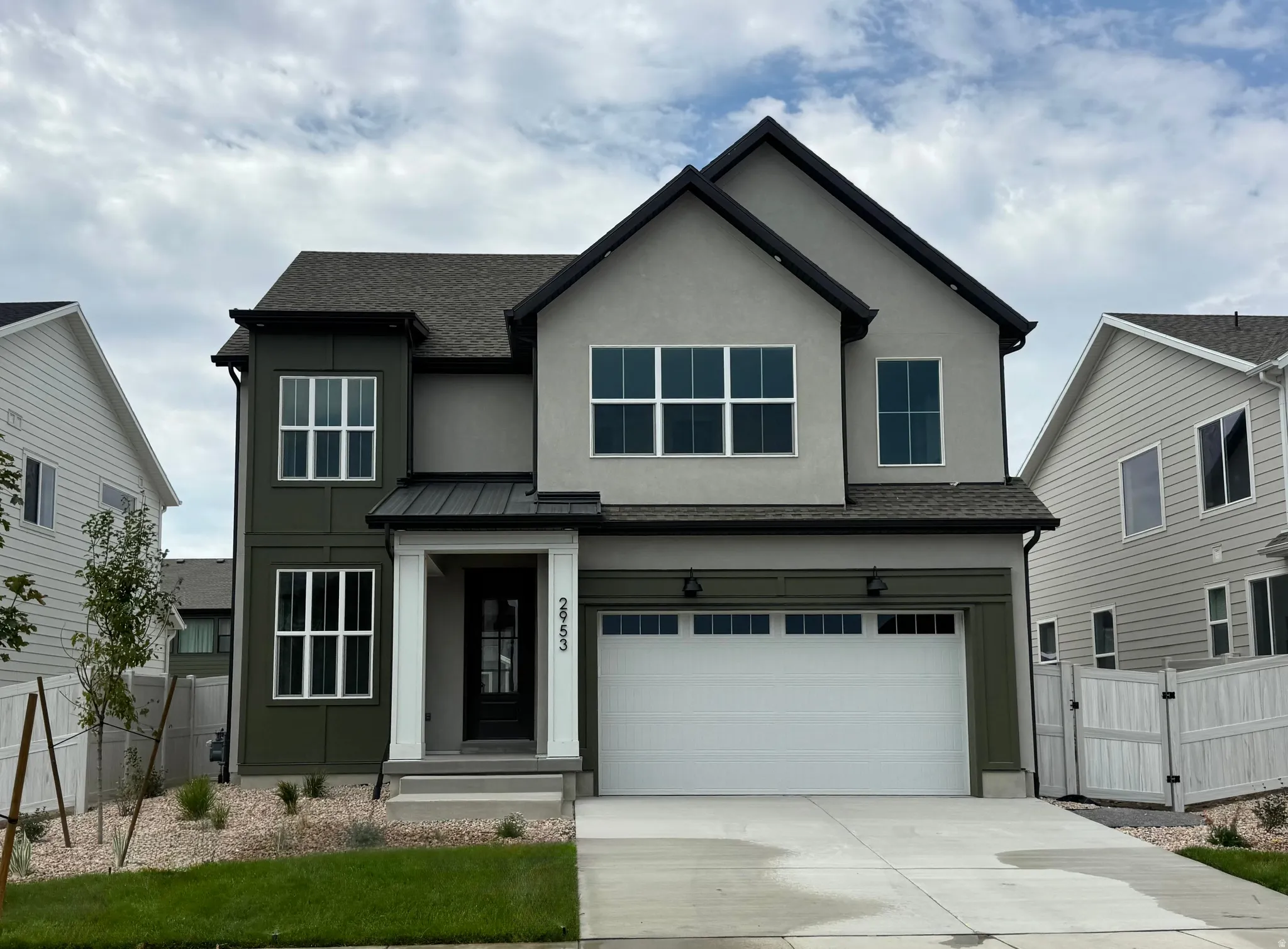 Two-story exterior with a two-car garage, covered entry, and black trim windows