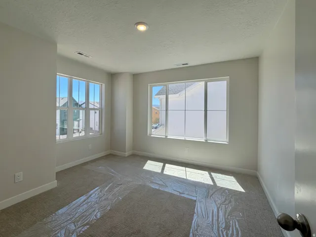 Neutral-toned interior room featuring two large multi-pane windows and recessed lighting
