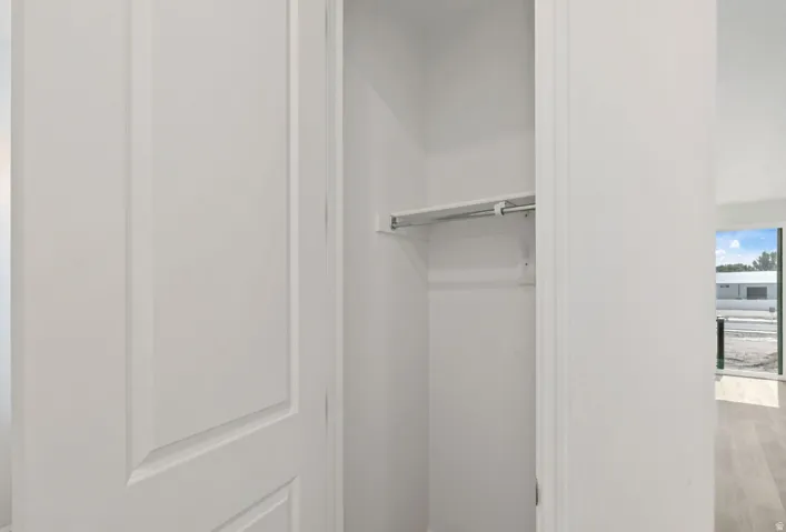 White interior door with paneling, featuring an interior closet with a hanging rod and shelf