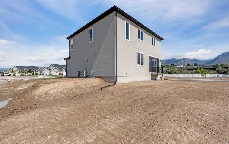 Two-story stucco exterior with a dark roofline, multiple windows, and a sliding glass door
