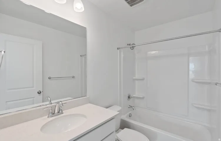 White vanity with a neutral countertop, undermount sink, and chrome fixtures