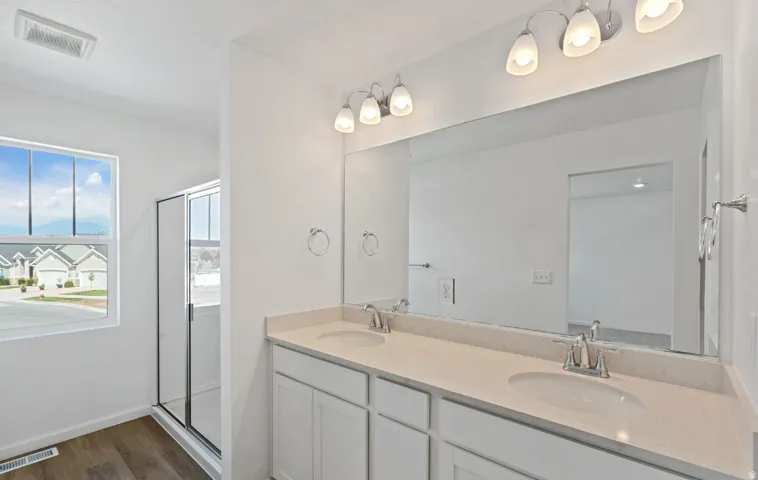 Dual vanity with undermount sinks, integrated countertop, and an expansive mirror