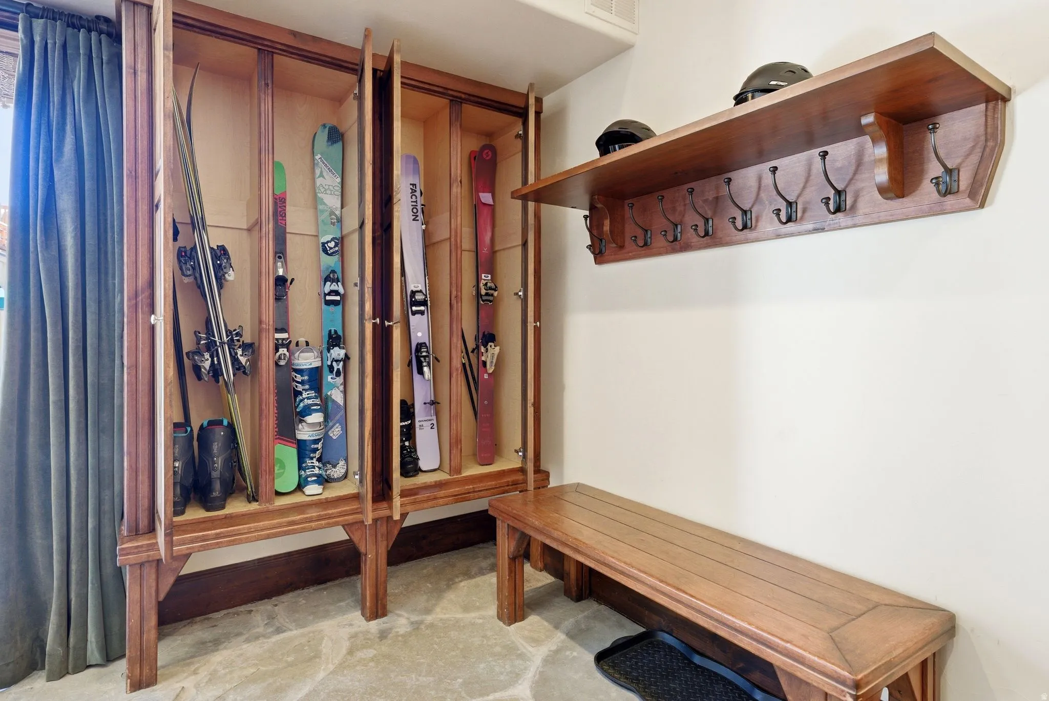 Custom wood-finish storage system featuring recessed compartments with clear panel doors, a built-in wood-finish bench, and a wall-mounted wood-finish shelf with integrated coat hooks