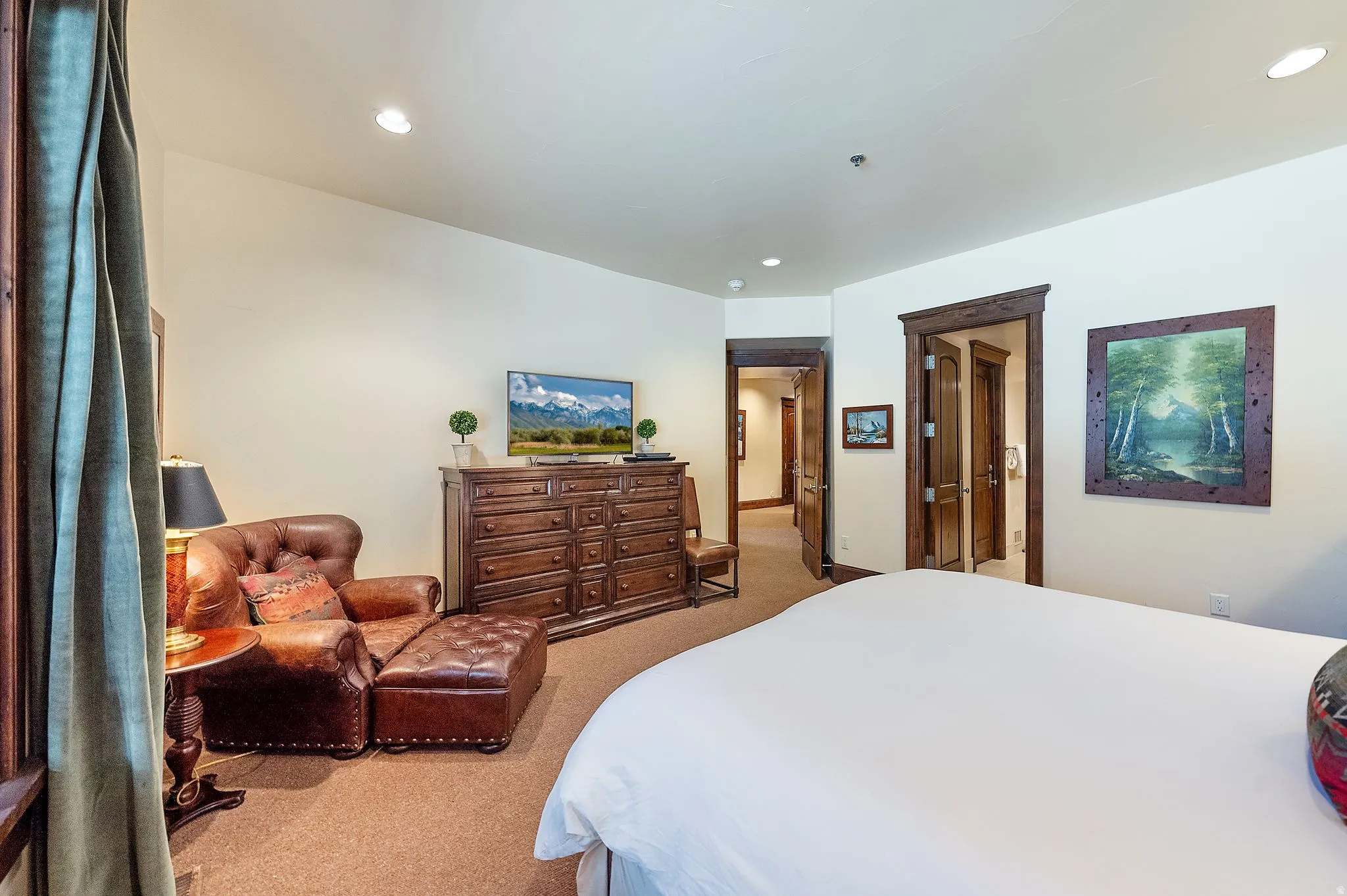 Recessed lighting illuminating a spacious room with light-toned walls and wood-finish door frames
