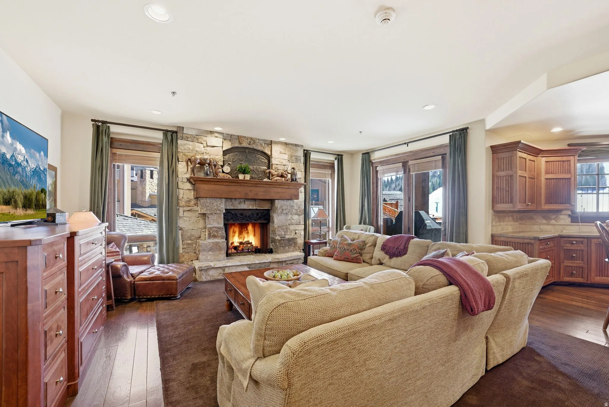 Spacious living area featuring a stone fireplace with a wood mantel