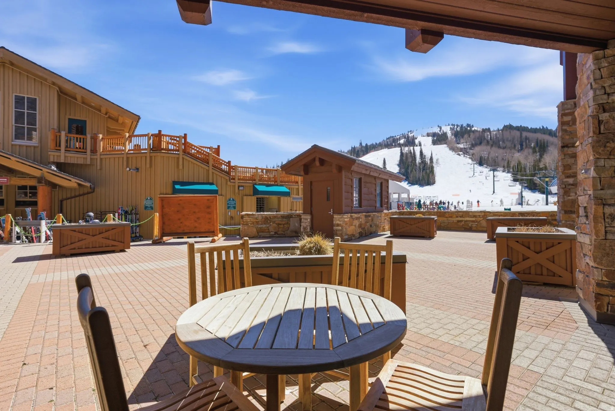 Expansive paver patio with a wooden outdoor dining set