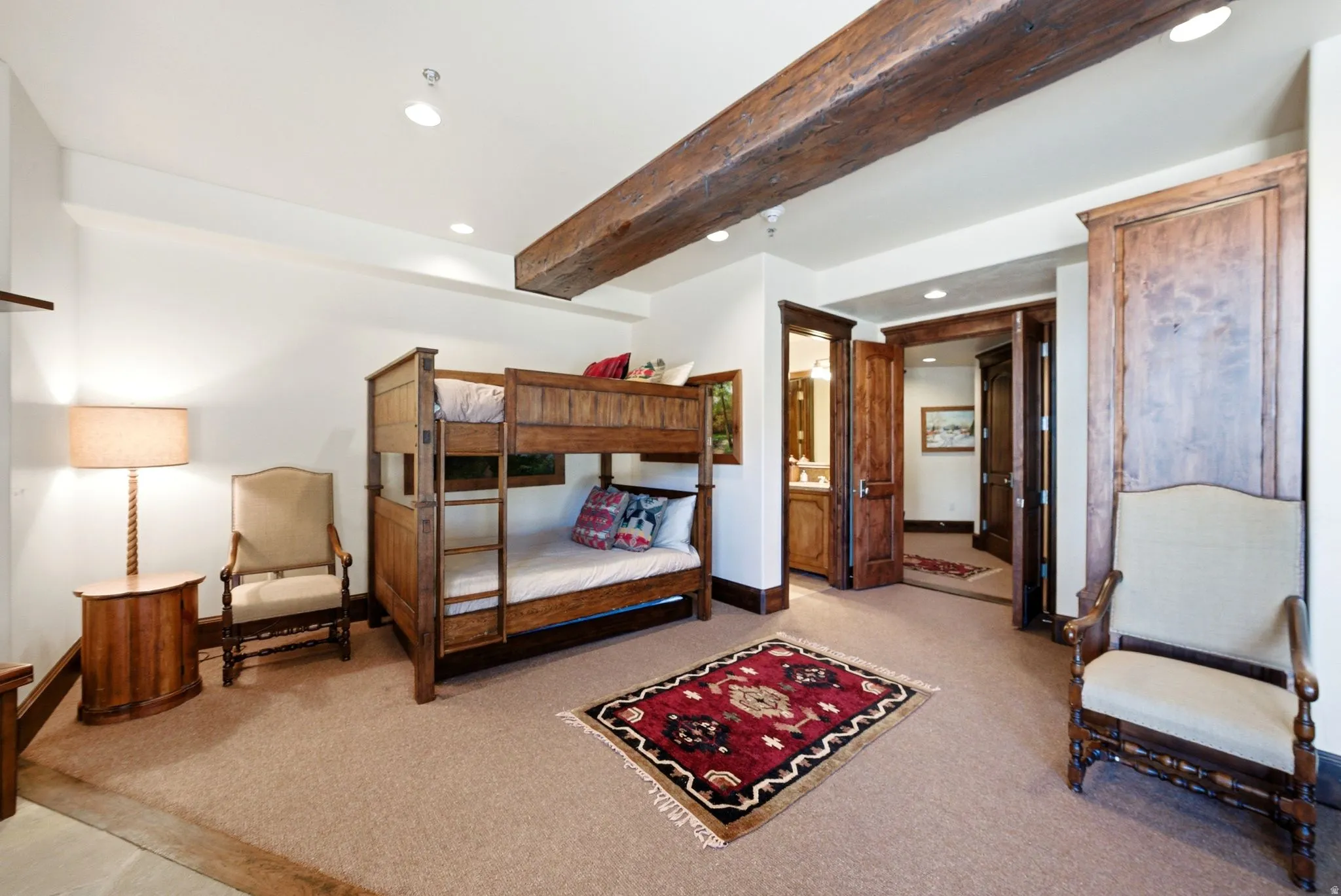 Room featuring a prominent exposed wood ceiling beam, plush carpet flooring, and recessed ceiling lighting