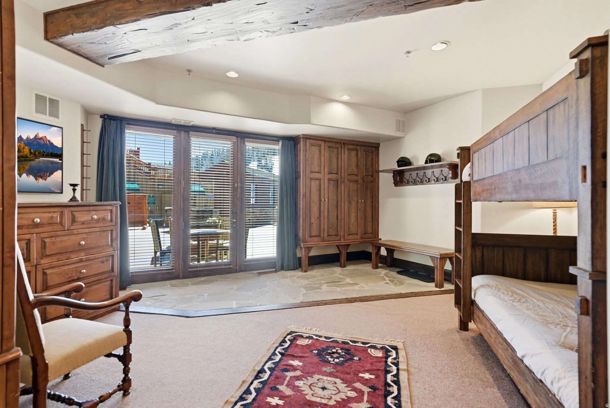 Room featuring exposed ceiling beams, French doors with integrated blinds, and stone-finish flooring