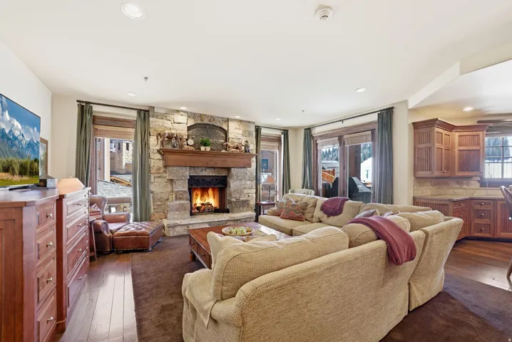 Spacious living area featuring a stone fireplace with a wood mantel