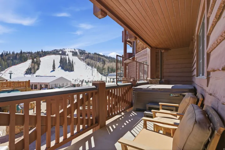 Private balcony featuring an integrated hot tub and direct ski slope frontage