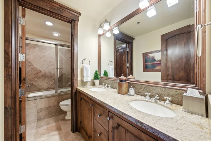 Dual vanity with light-toned countertop, integrated sinks, and polished chrome faucets
