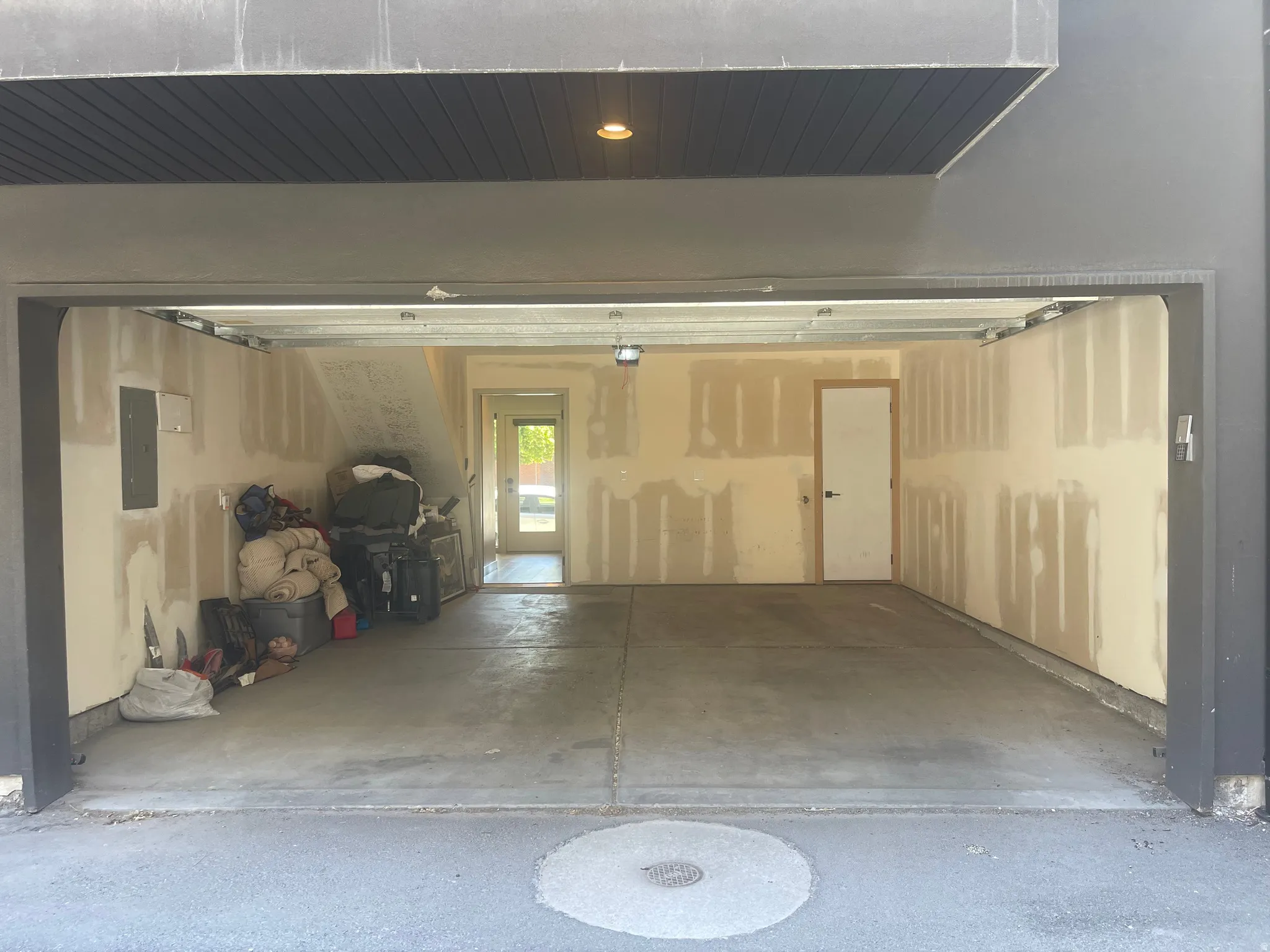 Spacious garage featuring a concrete floor, exposed drywall walls, and a recessed ceiling light