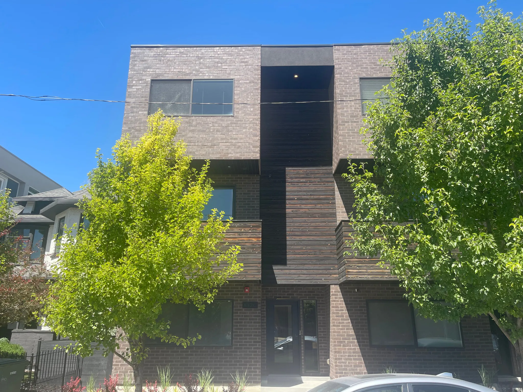 Modern façade featuring multi-toned brick and horizontal wood-finish siding