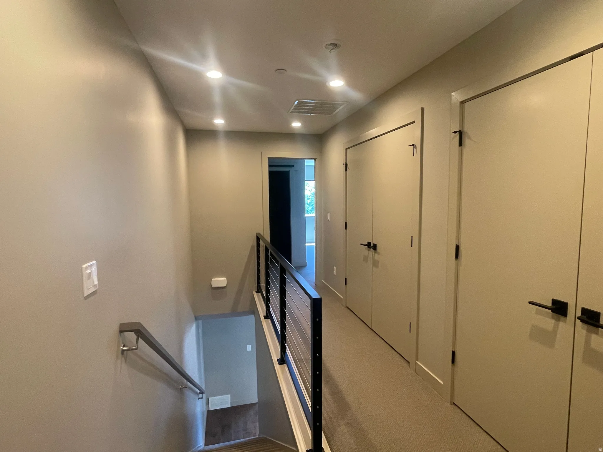 Hallway with recessed lighting, light gray walls, and carpeted flooring