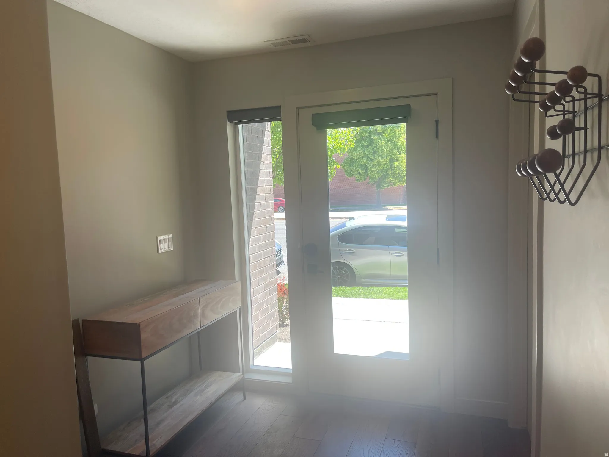 1st floor Entryway West Temple featuring a full-light door with integrated blind, wood-finish flooring, and a sidelight window