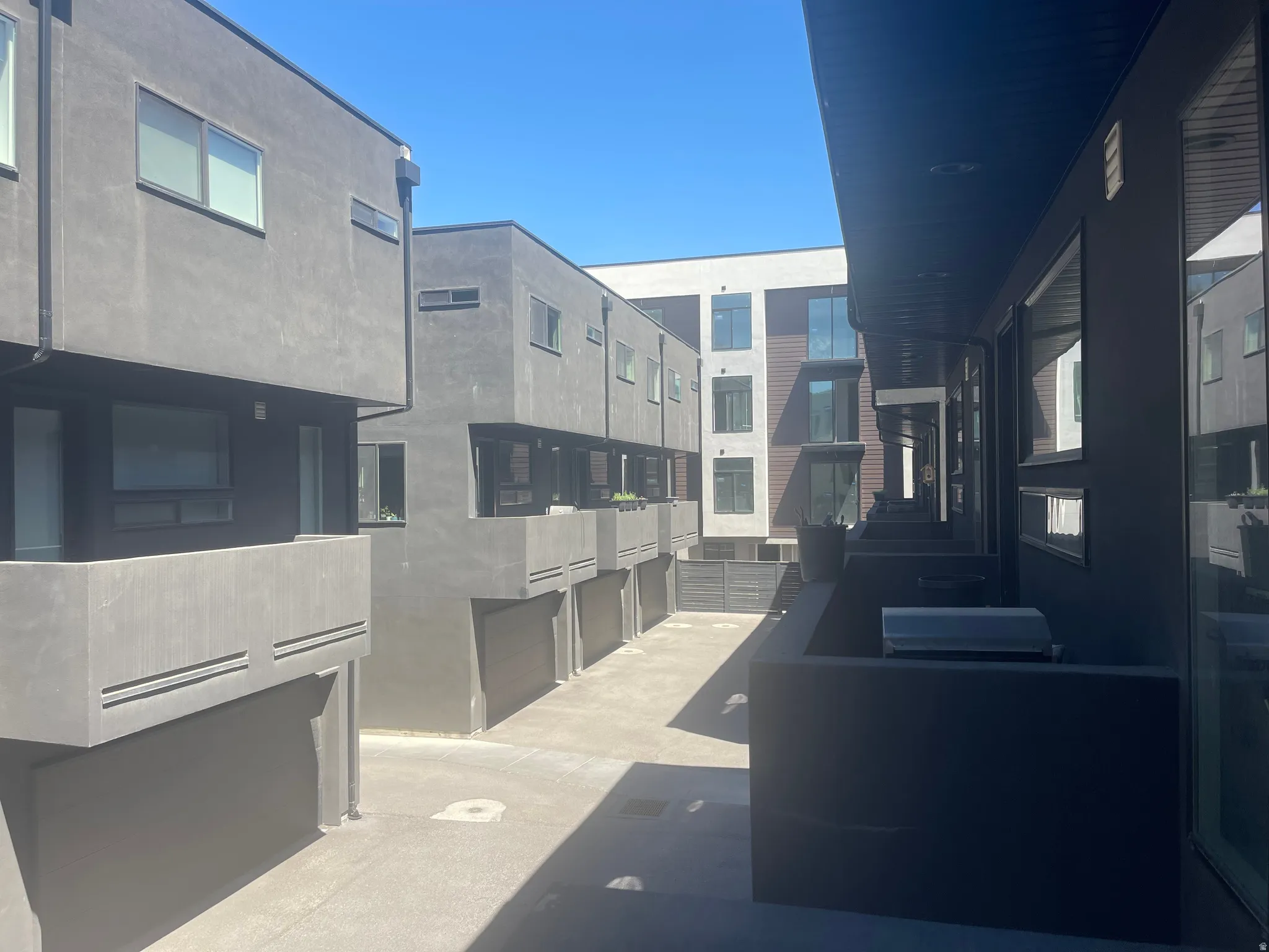 Modern townhome exterior featuring a stucco finish, multiple windows, and a private balcony