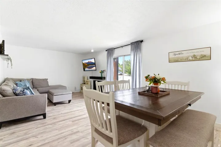 Open-concept living area with light wood-finish flooring, white walls, and recessed lighting