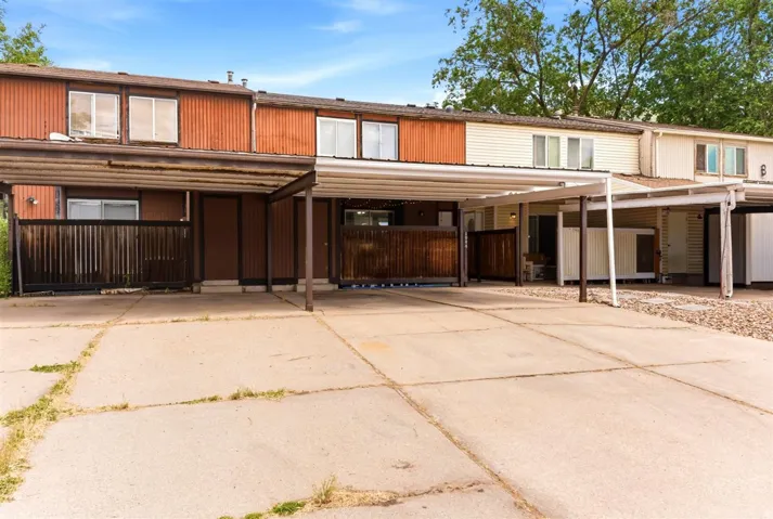 Multi-unit residential property featuring carports and concrete driveways