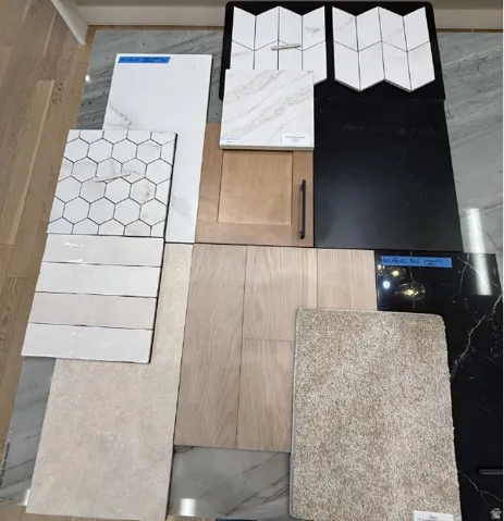 Selection of interior finishes including light wood-finish flooring, various white and grey tile options, textured beige carpeting, a light wood cabinet door with a matte black pull, and dark countertops