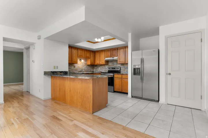 Kitchen featuring granite countertops and stainless steel appliances- unstaged