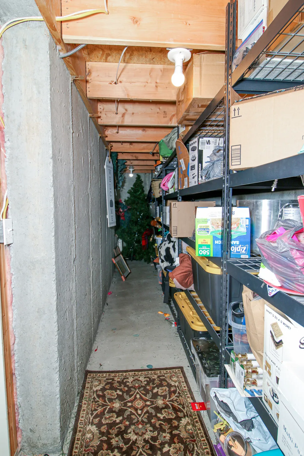 Unfinished basement area featuring exposed ceiling joists and concrete foundation walls