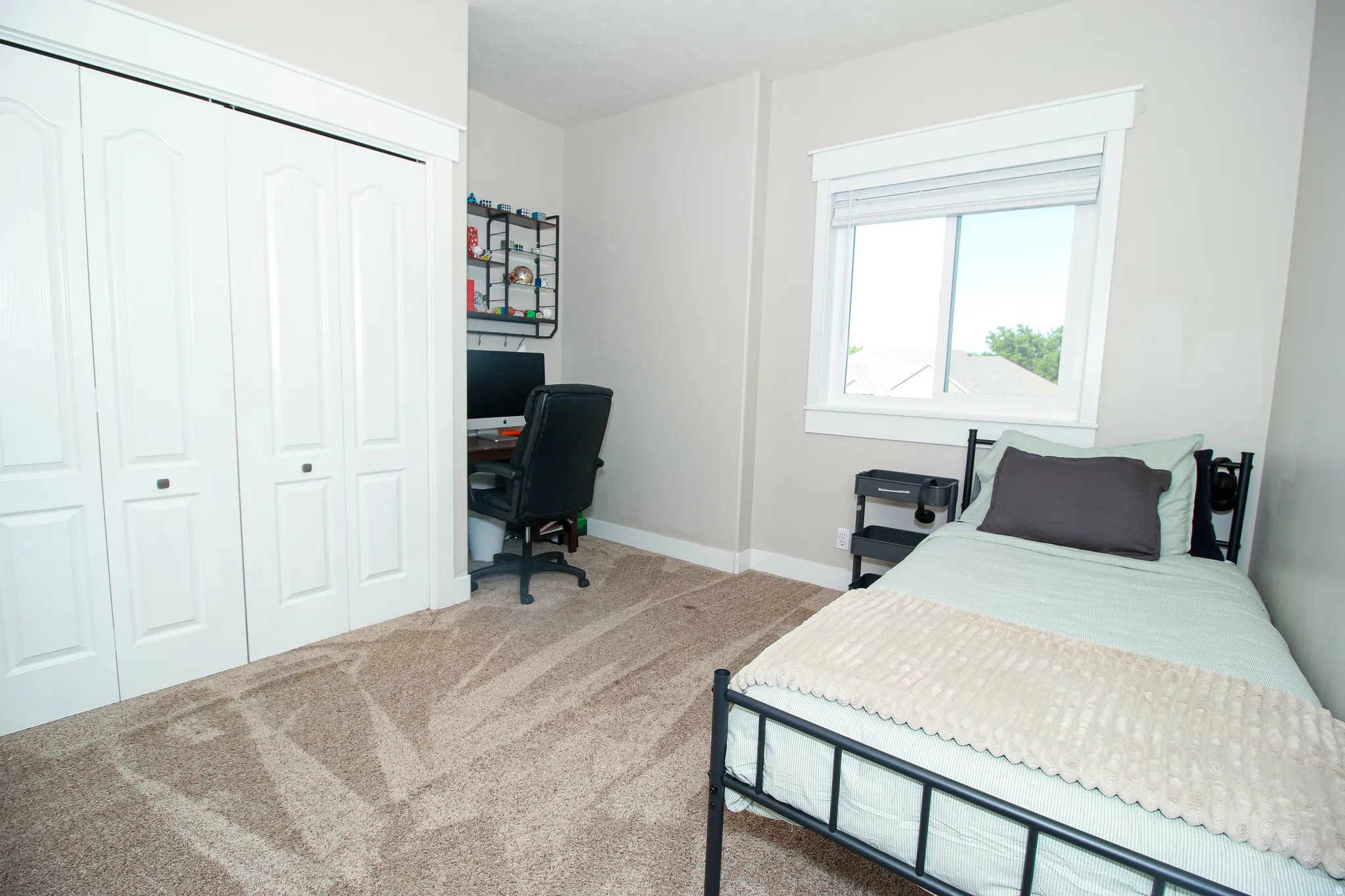 Room featuring light neutral wall paint, a window with white trim, and light beige carpet