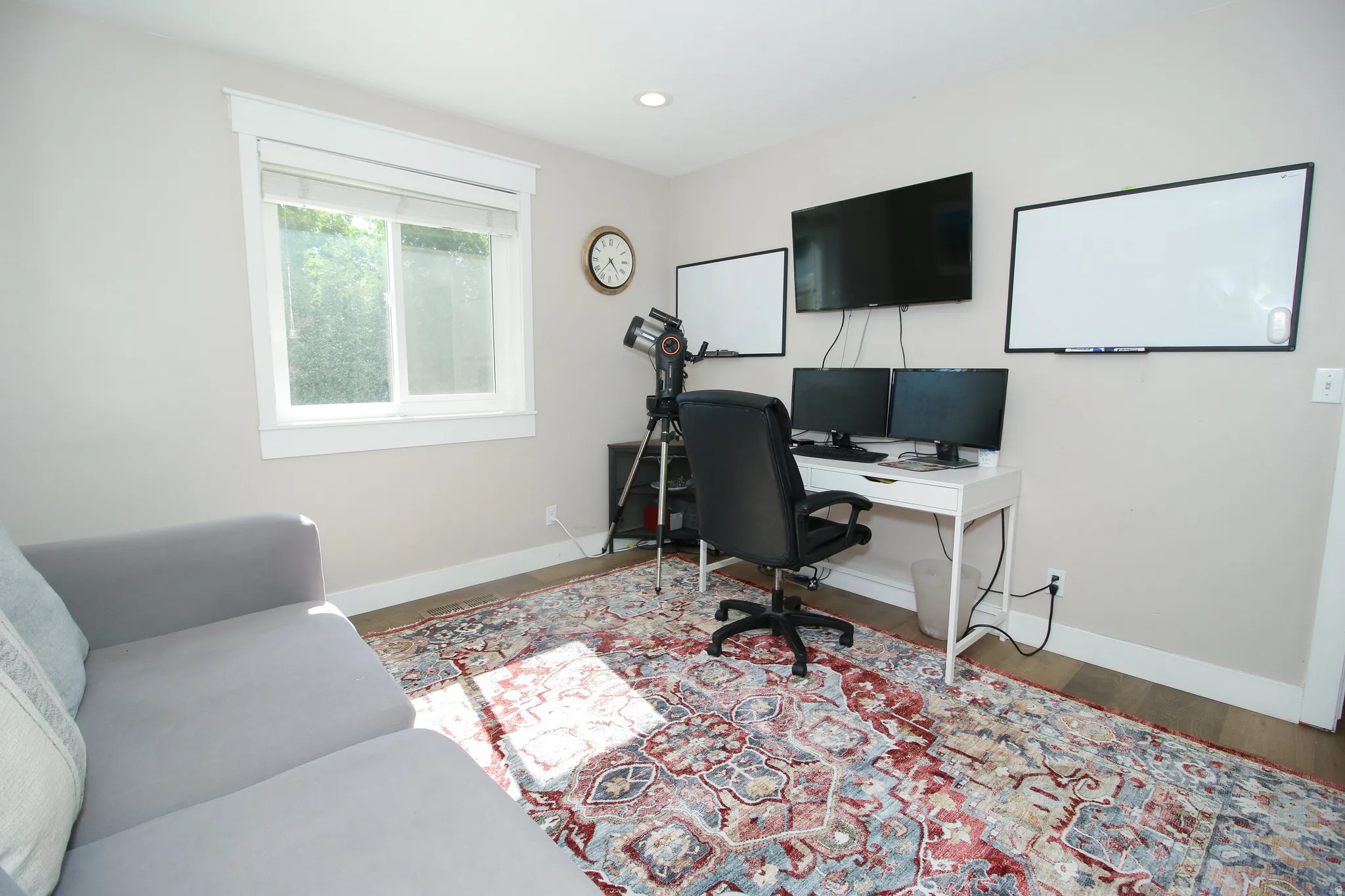 Bright room featuring light-toned walls and wood-finish flooring