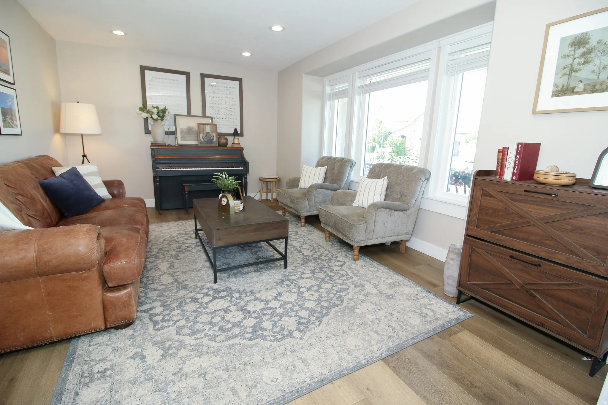 Bright room featuring large windows, wood-finish flooring, recessed lighting, and light-toned walls