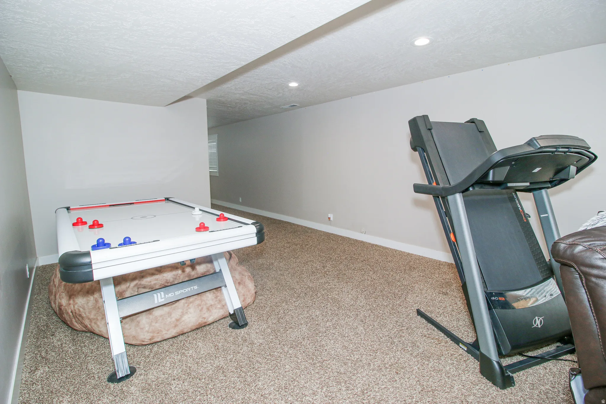 Spacious room featuring neutral carpet flooring and recessed lighting