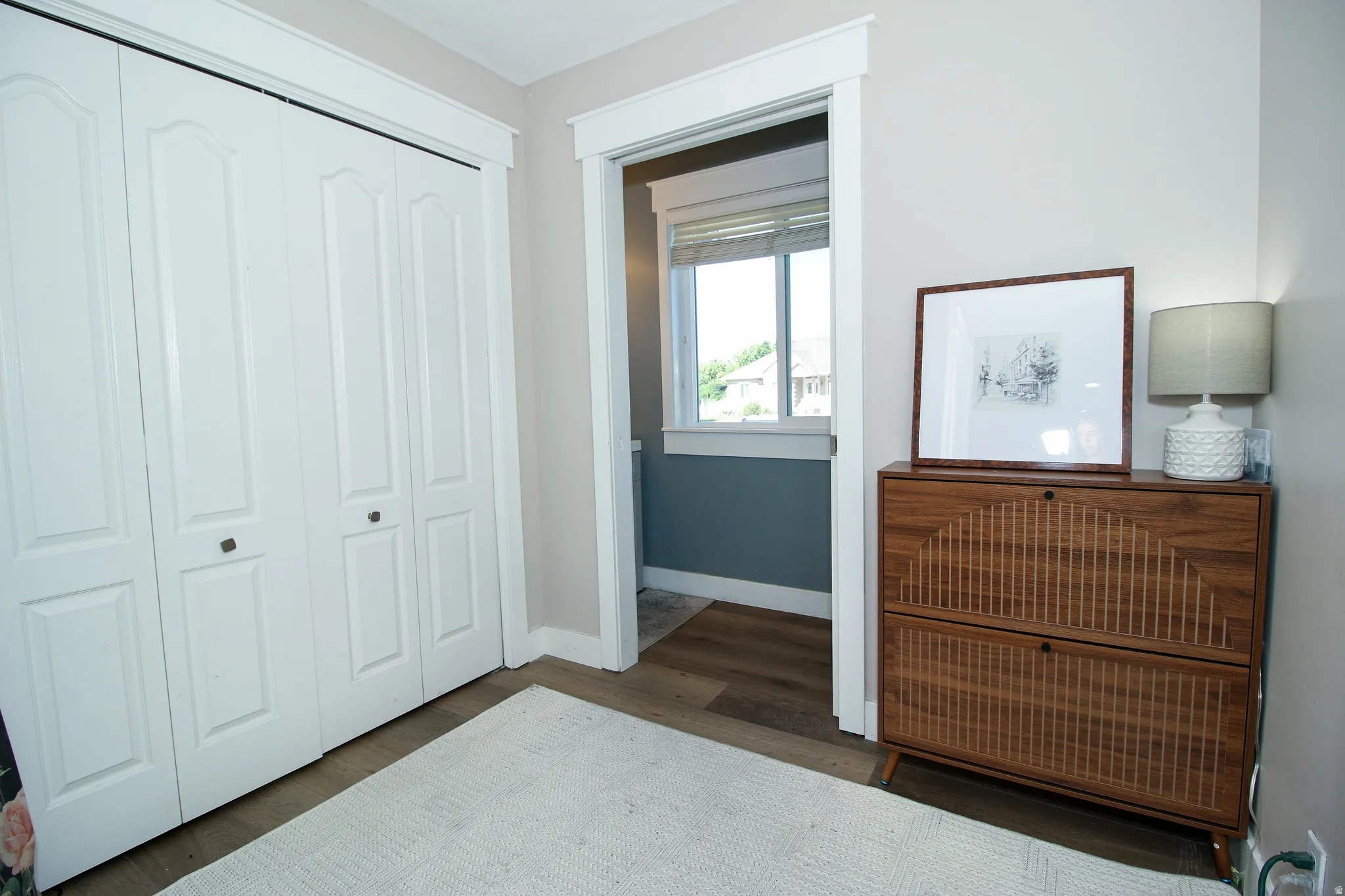 Wood-finish flooring with a light-toned area rug