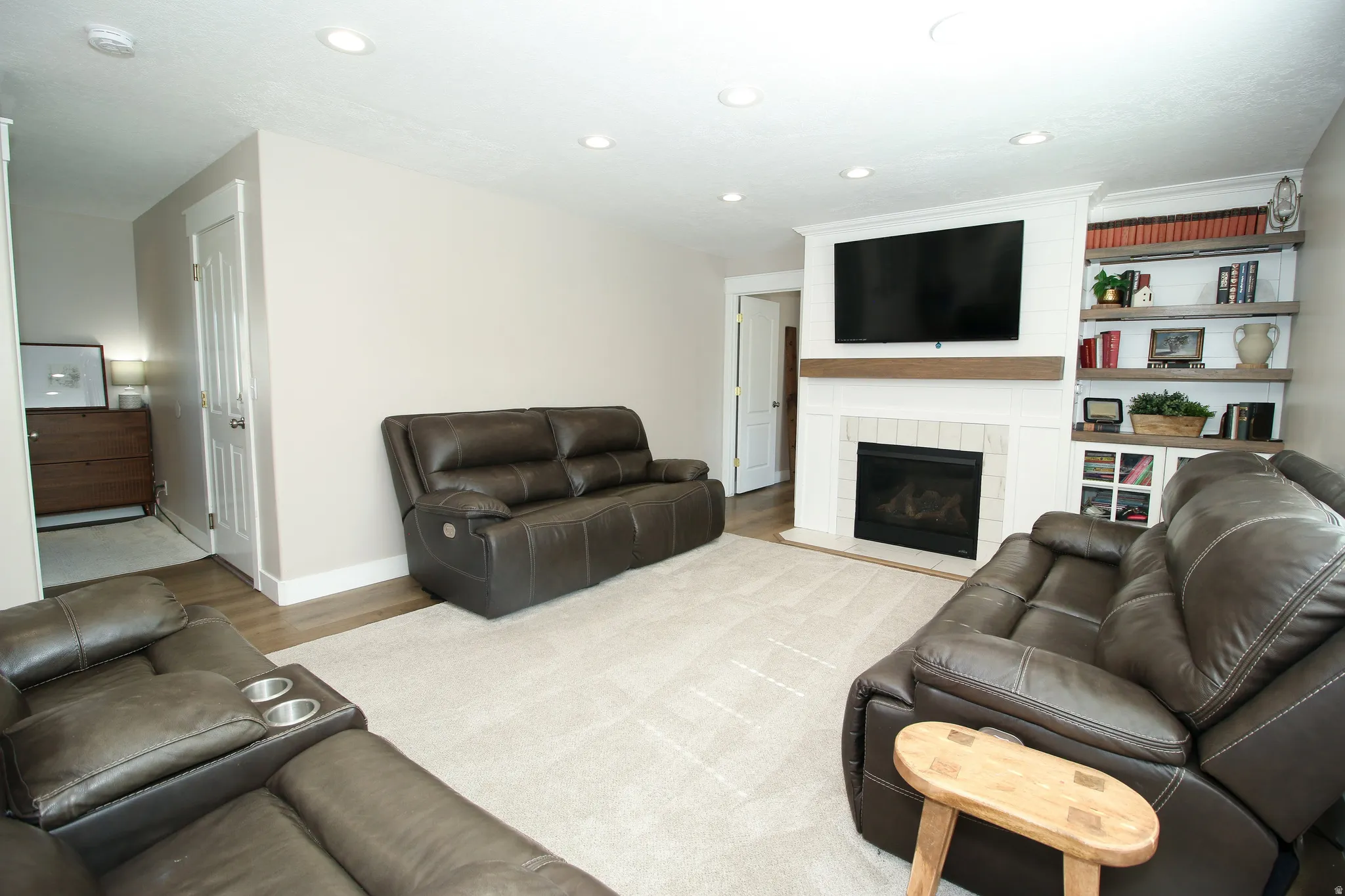 Living area with recessed lighting, light-toned walls, and wood-finish flooring