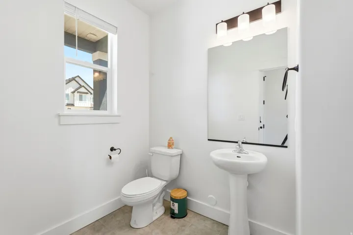 Pedestal sink with chrome faucet, large vanity mirror, and three-light vanity bar