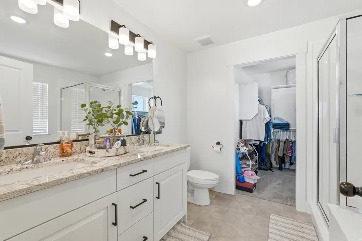 Double vanity with stone countertop, dual sinks, and matte black hardware