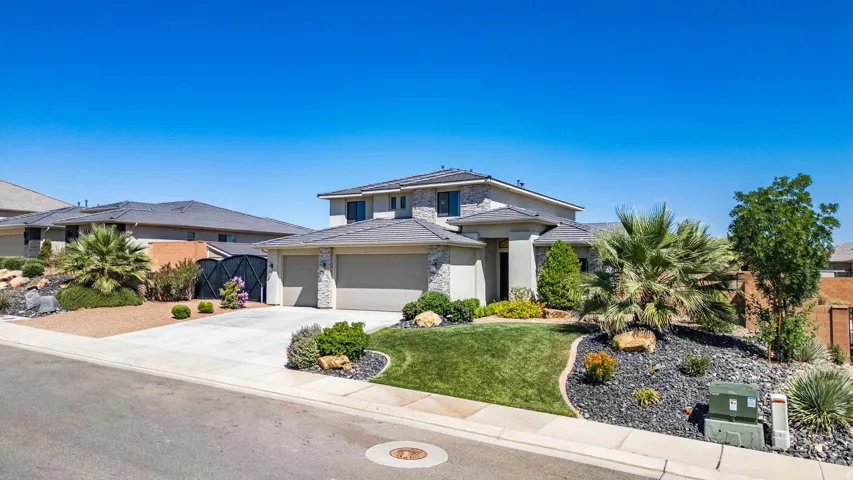 Contemporary two-story residence featuring a stone and stucco exterior, a two-car garage, and a concrete driveway