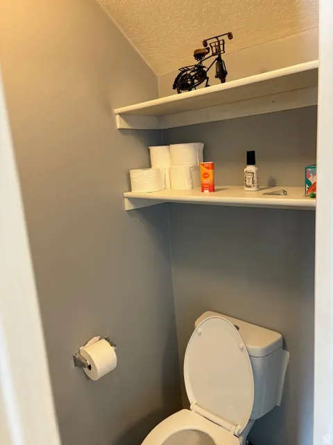 White toilet with a matching seat, accompanied by a wall-mounted toilet paper holder