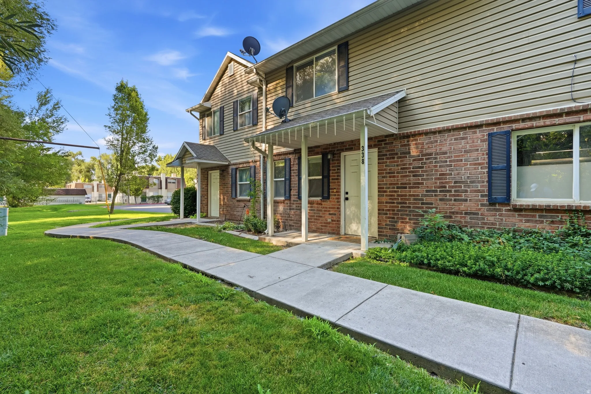 Brick and siding exterior featuring multiple entryways and a covered porch