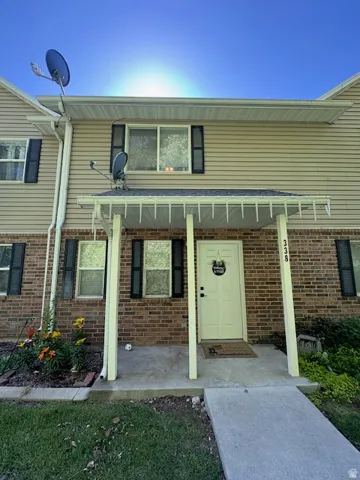 Two-story facade featuring a brick lower level and horizontal siding upper level