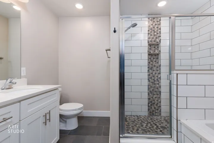 Bathroom featuring a glass-enclosed shower with subway tile and a mosaic accent
