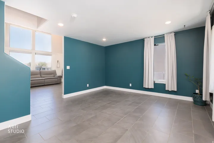 Spacious room featuring tile flooring, recessed lighting, and a bold accent wall